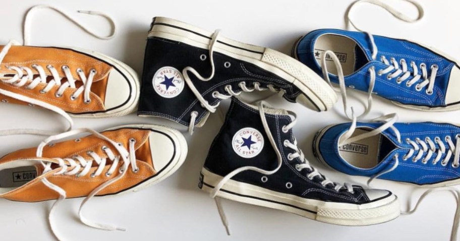 3 pairs of orange, black and blue Converse shoes with laces undone