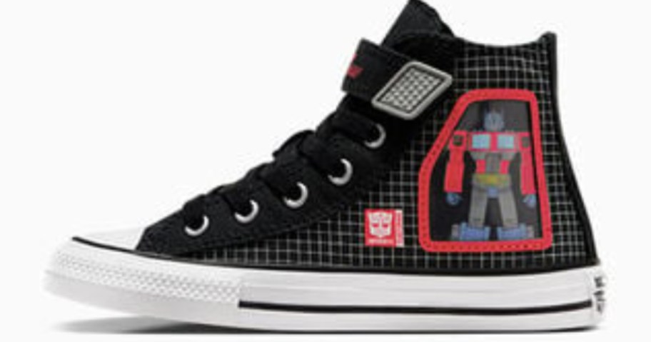 a kid's Converse Chuck Taylor shoe in a black and white with a Transformer robot on it