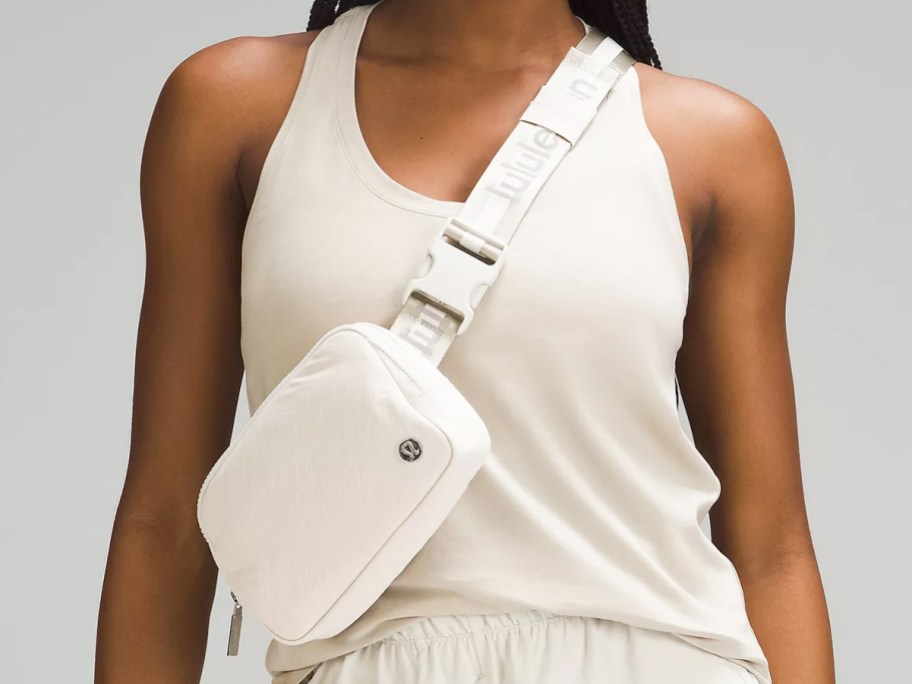 woman in a white outfit with a white belt bag across chest