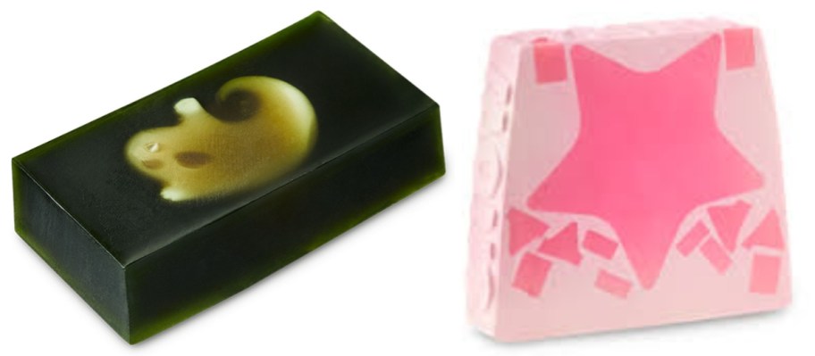 2 bars of soap, one is black with a white ghost shape in it, and one is white with pink stars