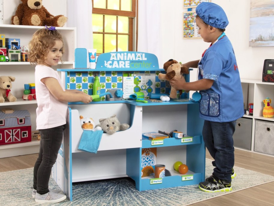 two kids playing at wooden pet groomer station