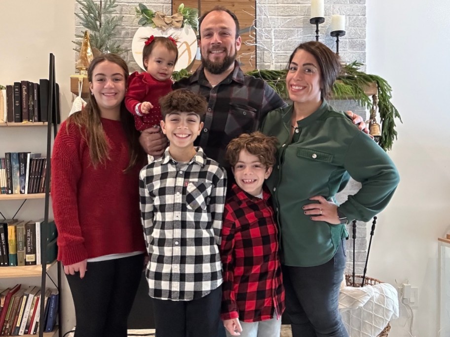 family wearing christmas coordinating outfits posing together in living room