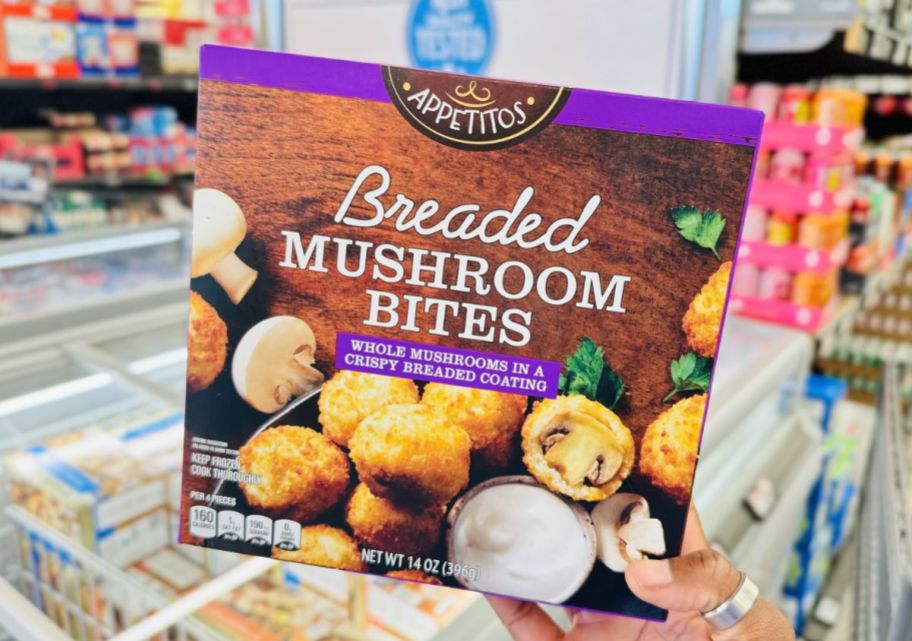 a womans hand holding a package of breaded mushroom bites