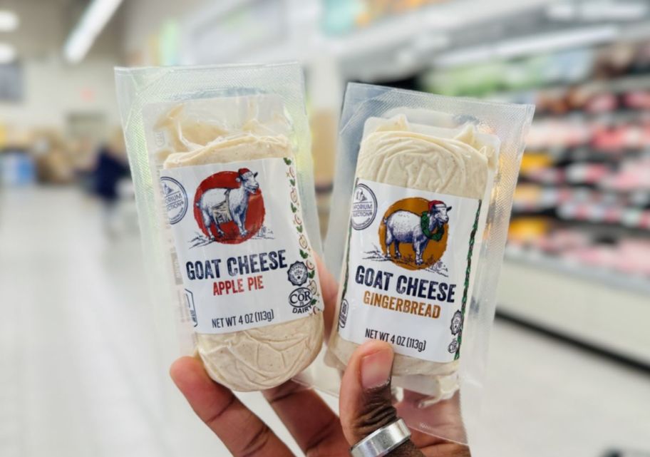 a womans hand holding 2 flavored goat cheeses