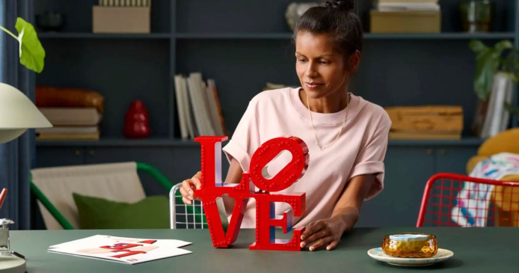 woman building lego love sculpture