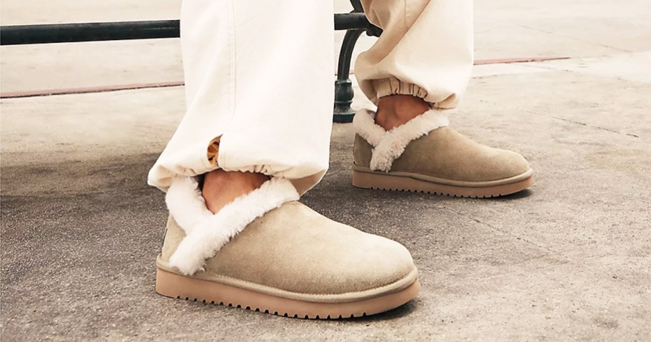 woman wearing pair of Koolaburra by UGG Suede Fur-Lined Slip-Ons