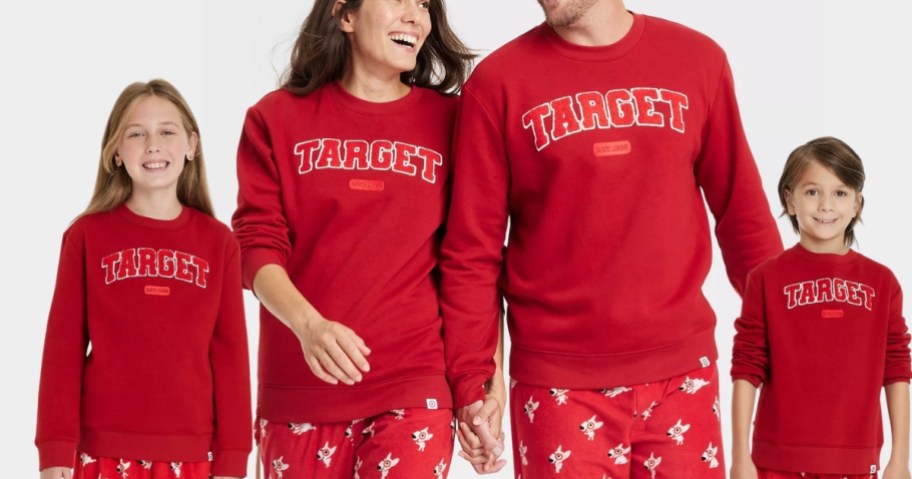 little girl, mom, dad, and little boy all wearing matching red color sweatshirts that have "Target" spelled out in block letters - they are Target store branded sweatshirts