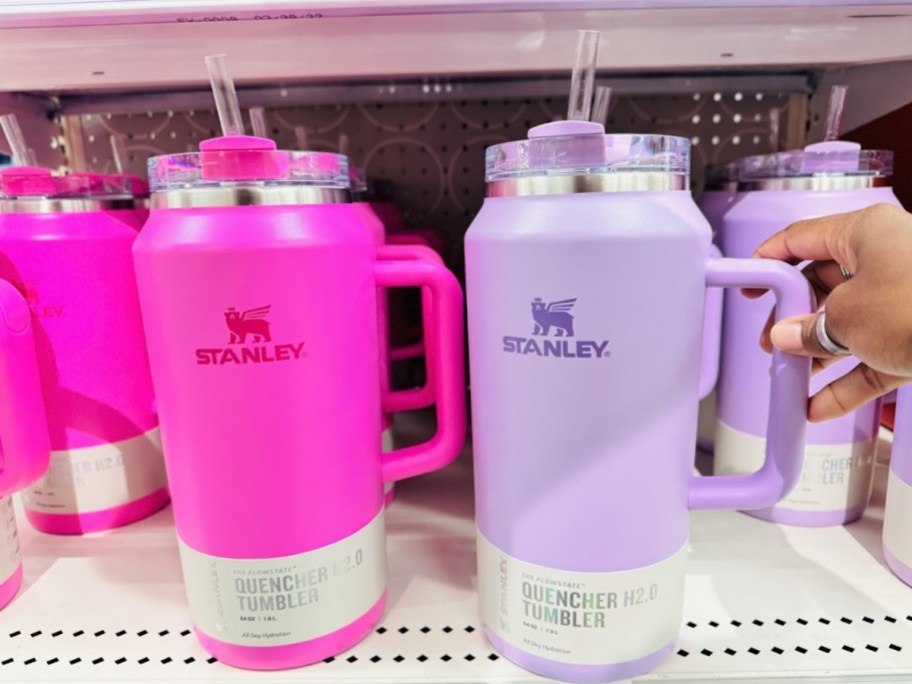 a bright pink and a pastel lavender large 64 oz Stanley tumblers on a Target shelf