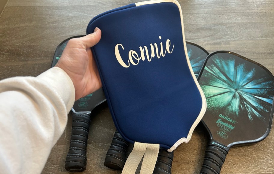 hand holding paddleboard cover with name connie on it 