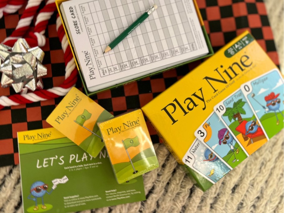 Play Nine card game box, cards, score card, pencil, and instructions laying on a present