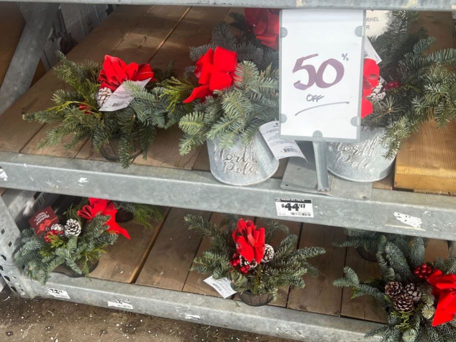 home depot holiday greenery on display outside with 50% off sign in front of it