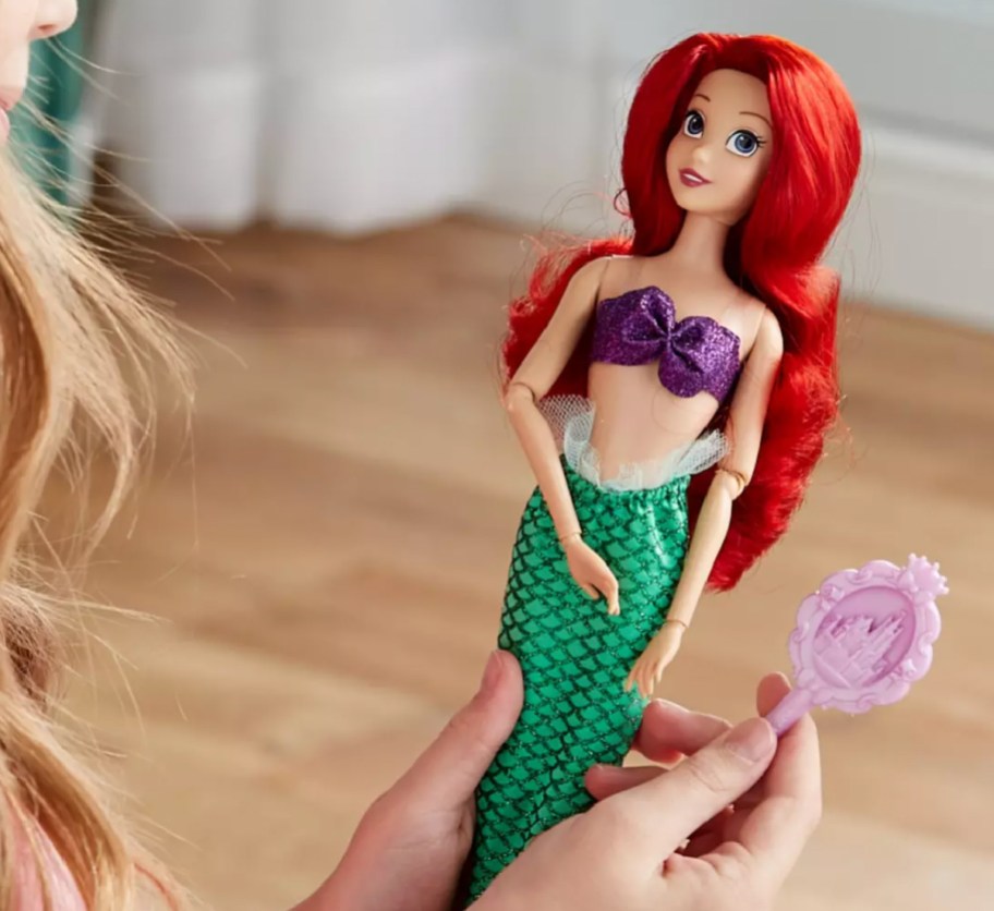 girl holding ariel doll