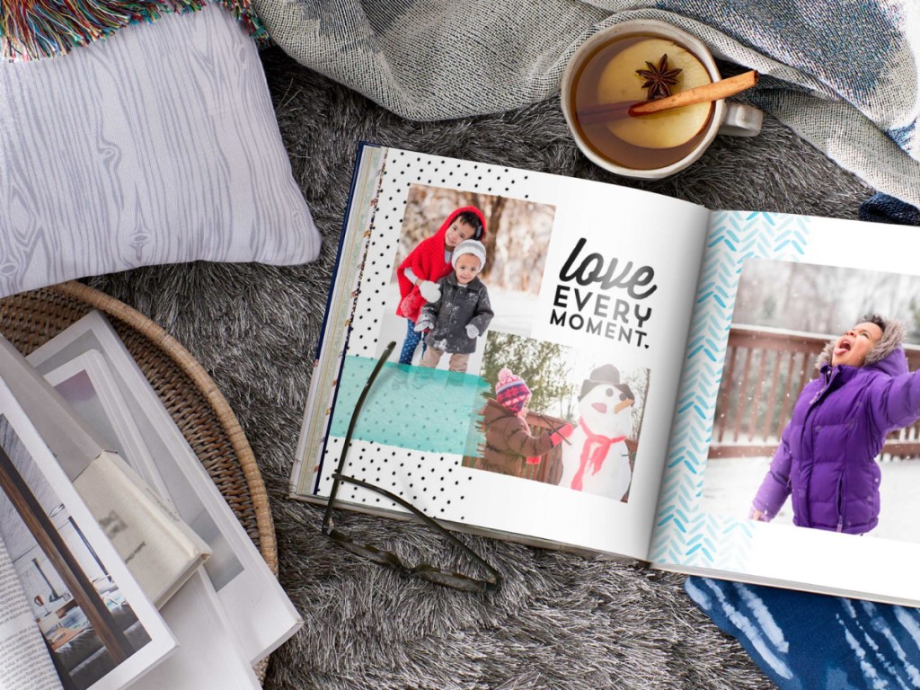 Open Shutterfly photo book on living room rug next to mug of Coco