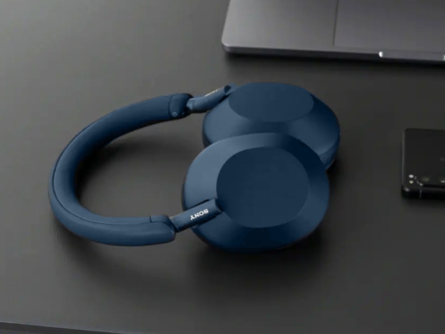 pair of blue sony headphones on a black desk