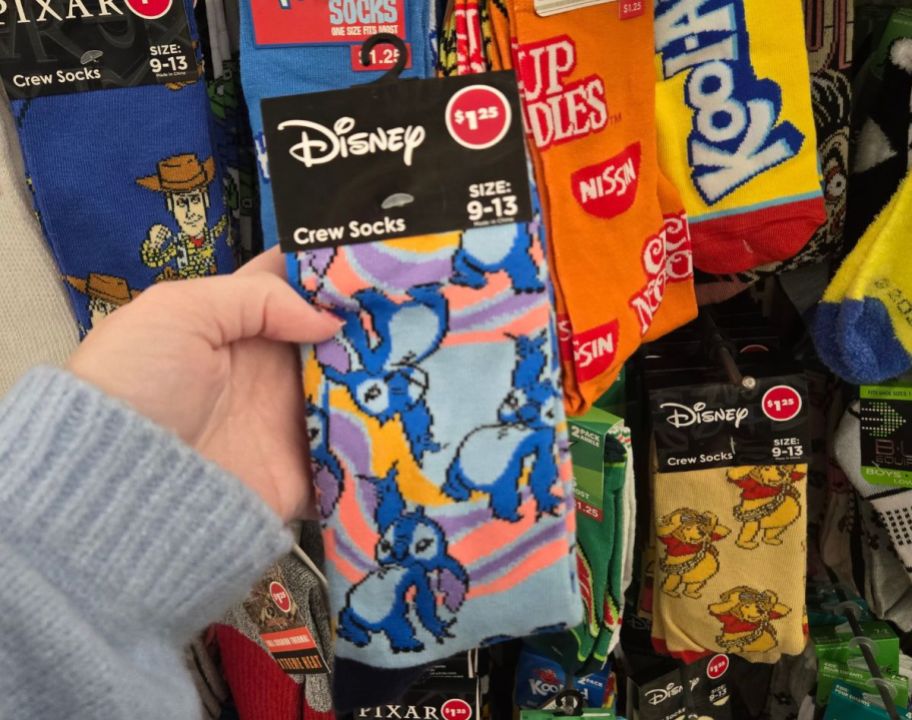 a womans hand holding a pair of character socks