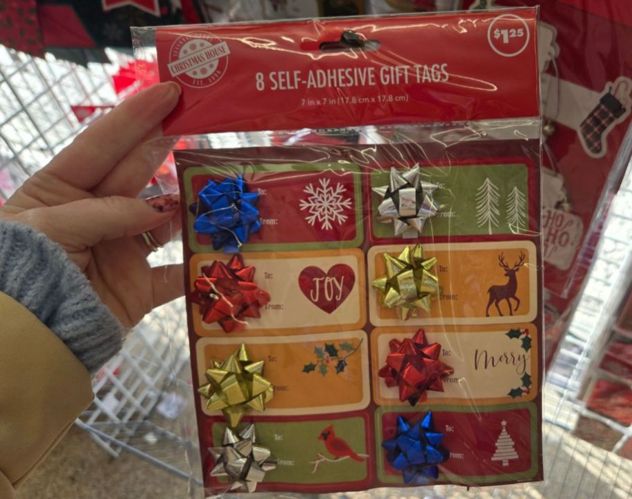 womans hand holding a pack of adhesive gift tags