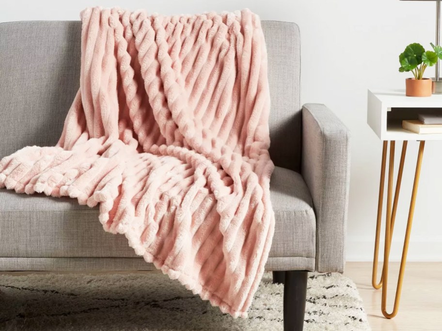 pink ribbed throw blanket draped over couch