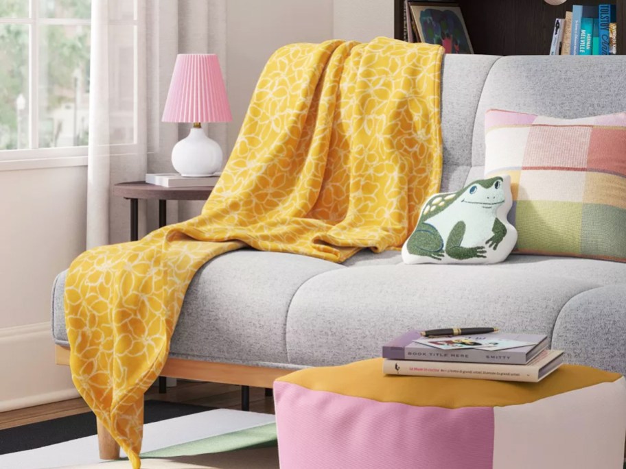 yellow floral print throw blanket draped over couch