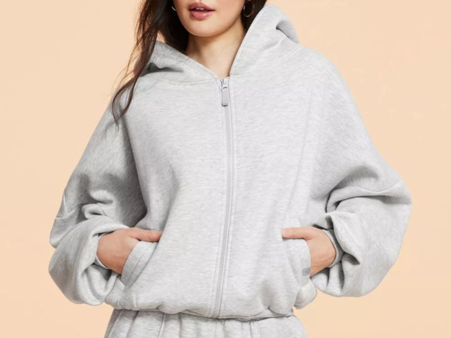 woman wearing a Blogilates Women's Marshmallow Full Zip Hooded Sweatshirt