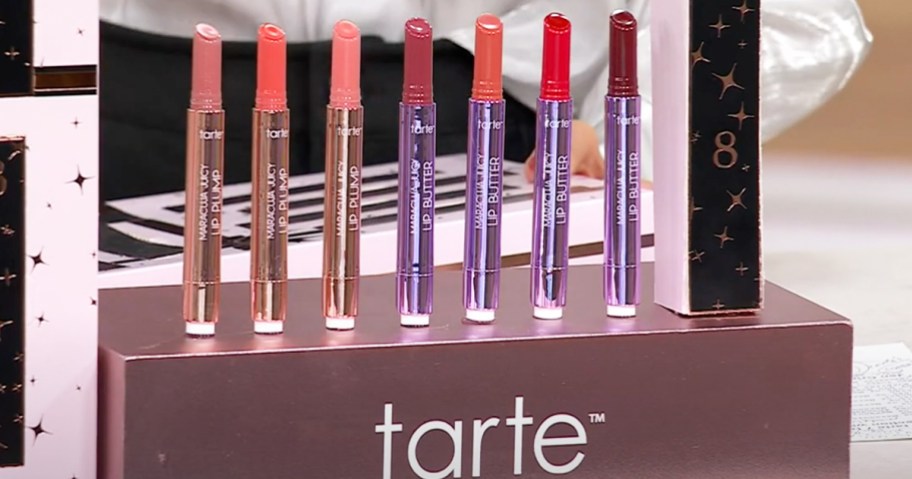 Tarte Maracuja Juicy Lip products standing in a row on display with a mystery box