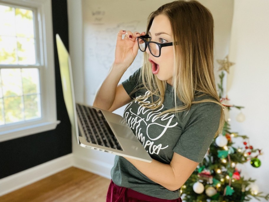 woman looking through glasses at laptop