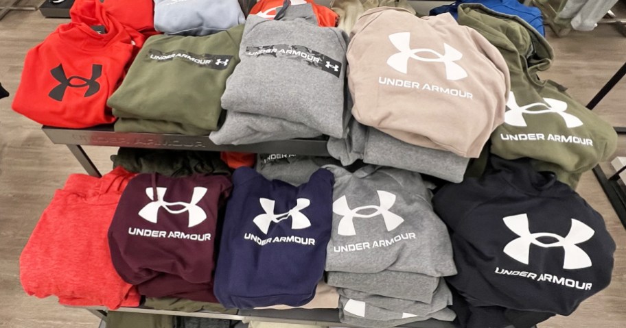 display table full of folded under armour hoodies