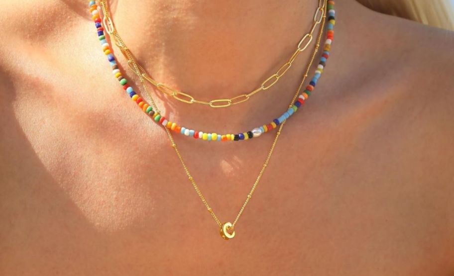 a womans neck shown wearing a 3 piece set of layering necklaces