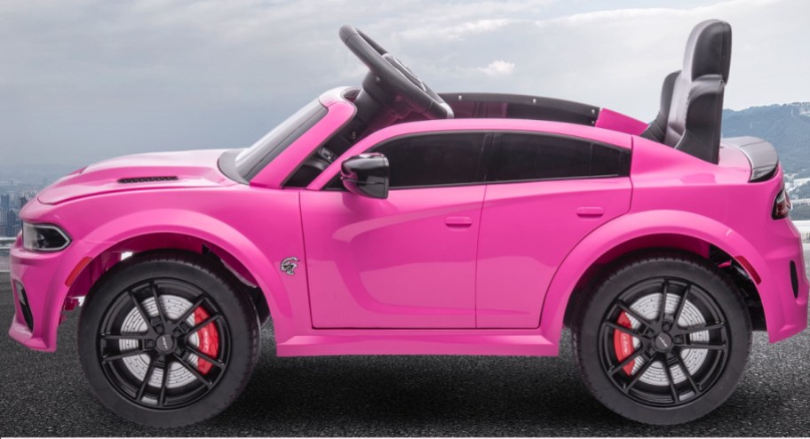 Pink ride on car displayed on an empty road