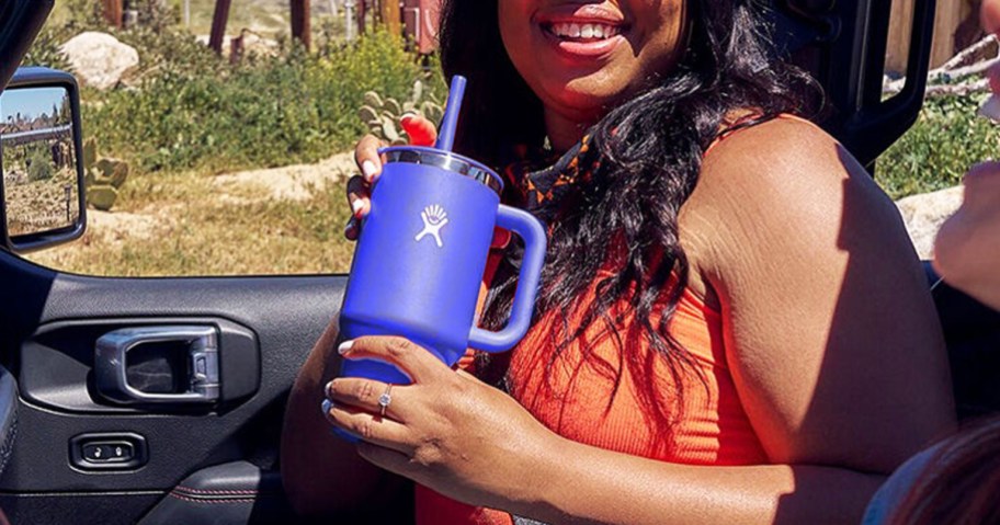 girl sitting in car holding a purple hydro flask tumbler