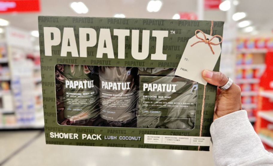 a womans hand holding a papatui shower ack gift set