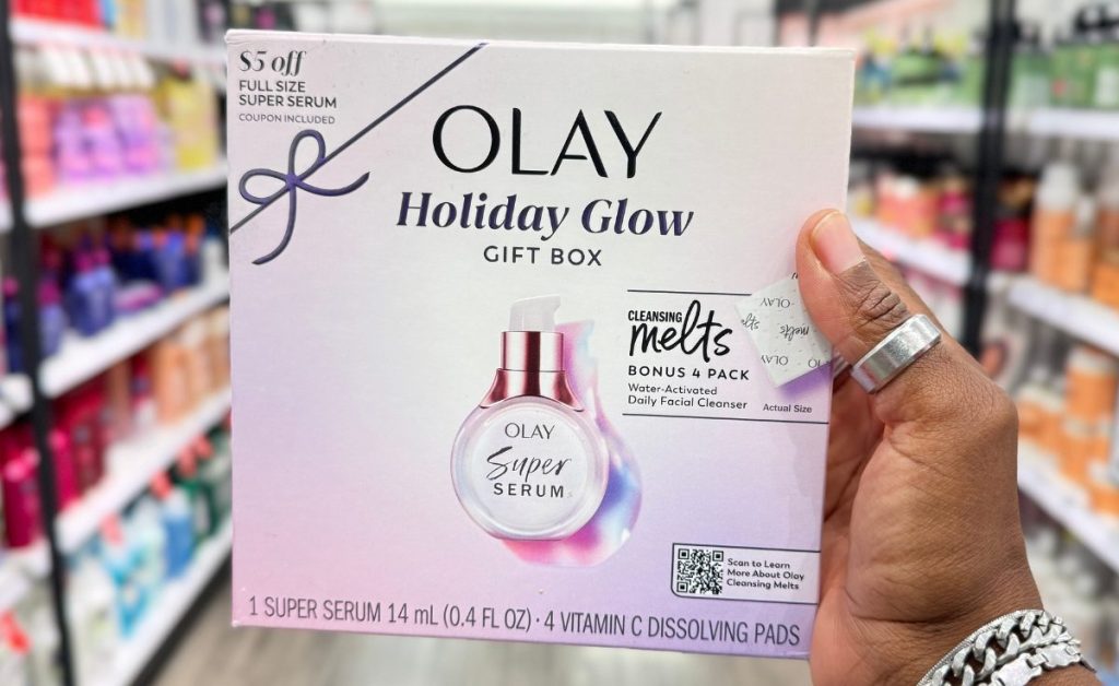 hand holding a pink box with a Olay Holiday Glow Kit featuring Super Serum Mini and Vitamin C Cleansing Melts Gift Set