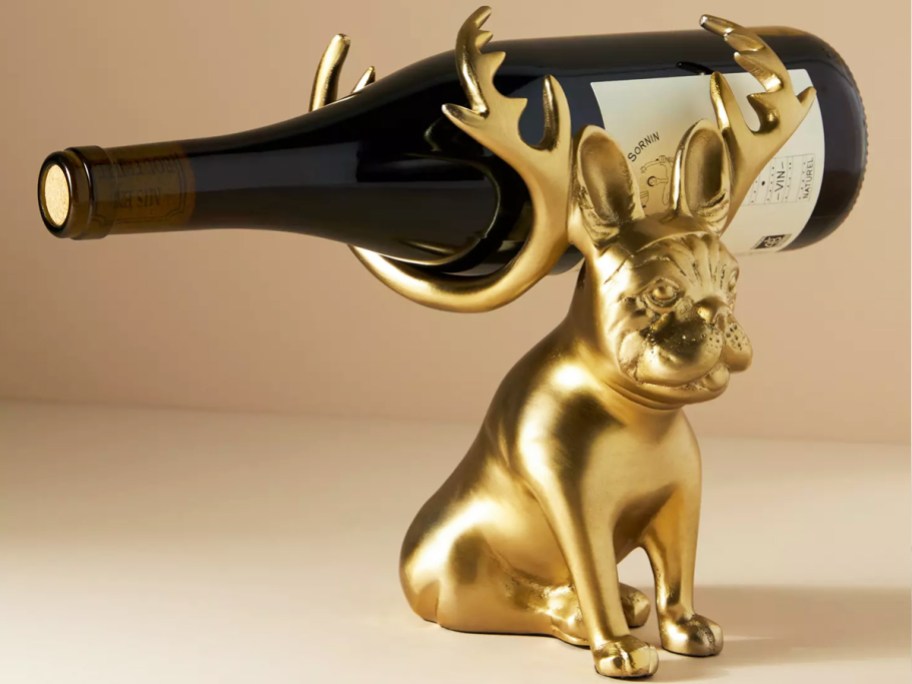 gold frenchie holding wine bottle with reindeer antlers