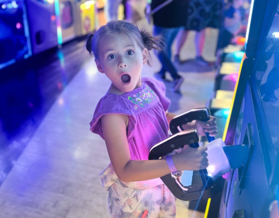 girl with surprised face playing at arcade