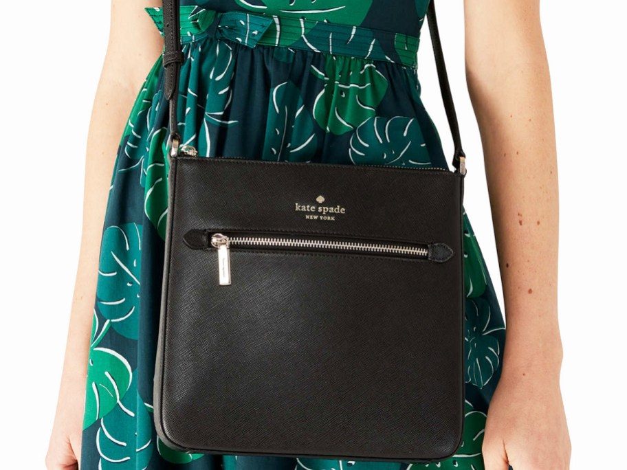 woman in green leaf print dress with black crossbody bag