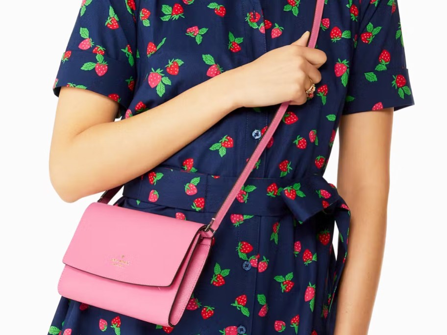 woman in strawberry print dress with pink crossbody bag