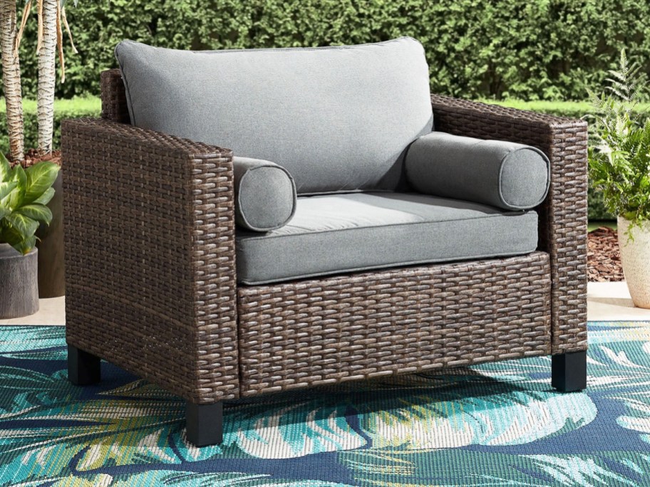 brown wicker patio chair with grey cushions