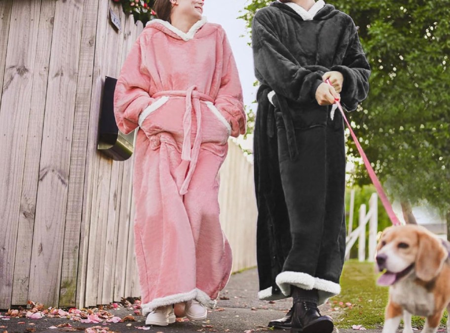 two people wearing pink and black wearable blankets