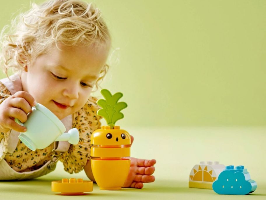 Little girl playing with a LEGO DUPLO My First Growing Carrot