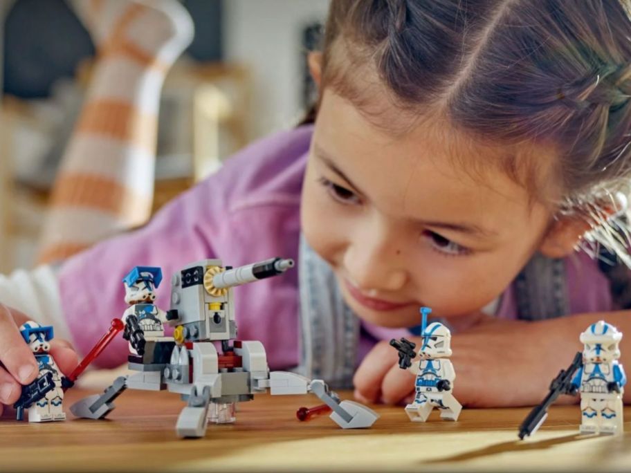 Little girl playing with a. LEGO Star Wars 501st Clone Troopers Battle Pack