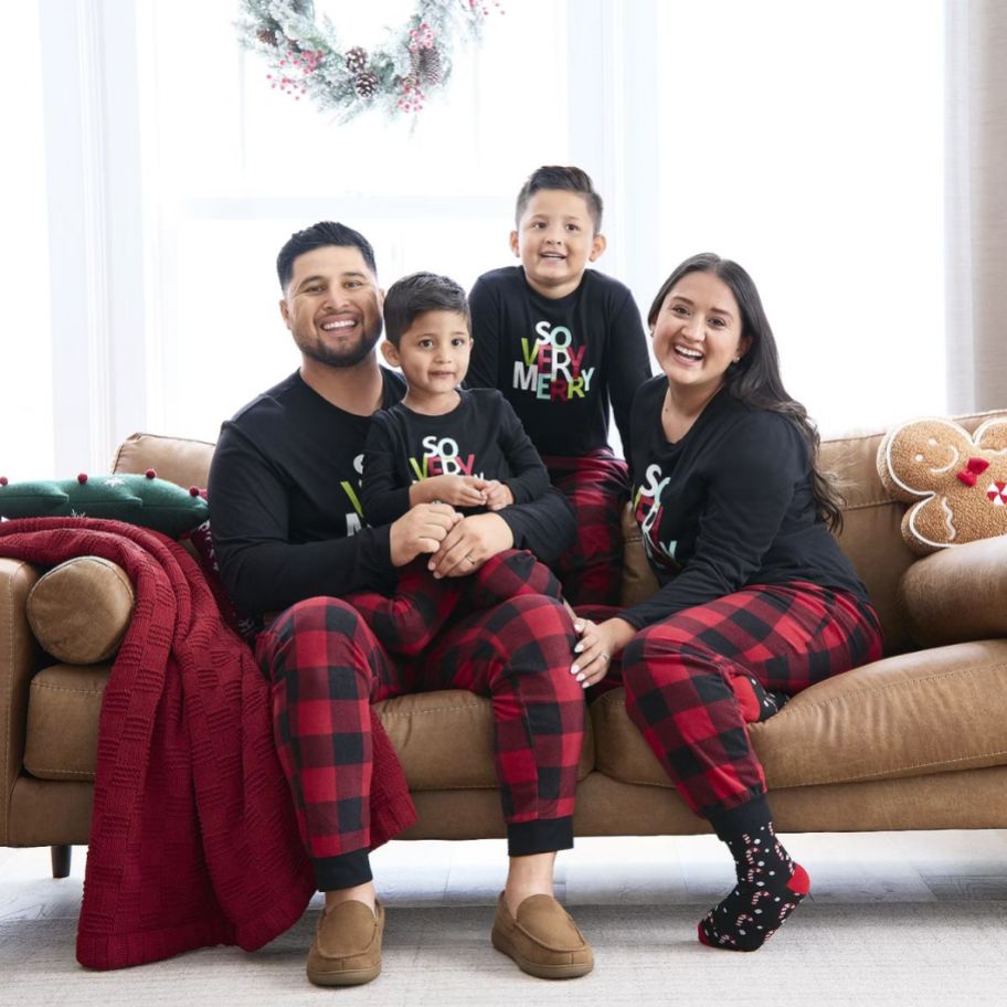 a family on a sofa wearing matching holiday pjs