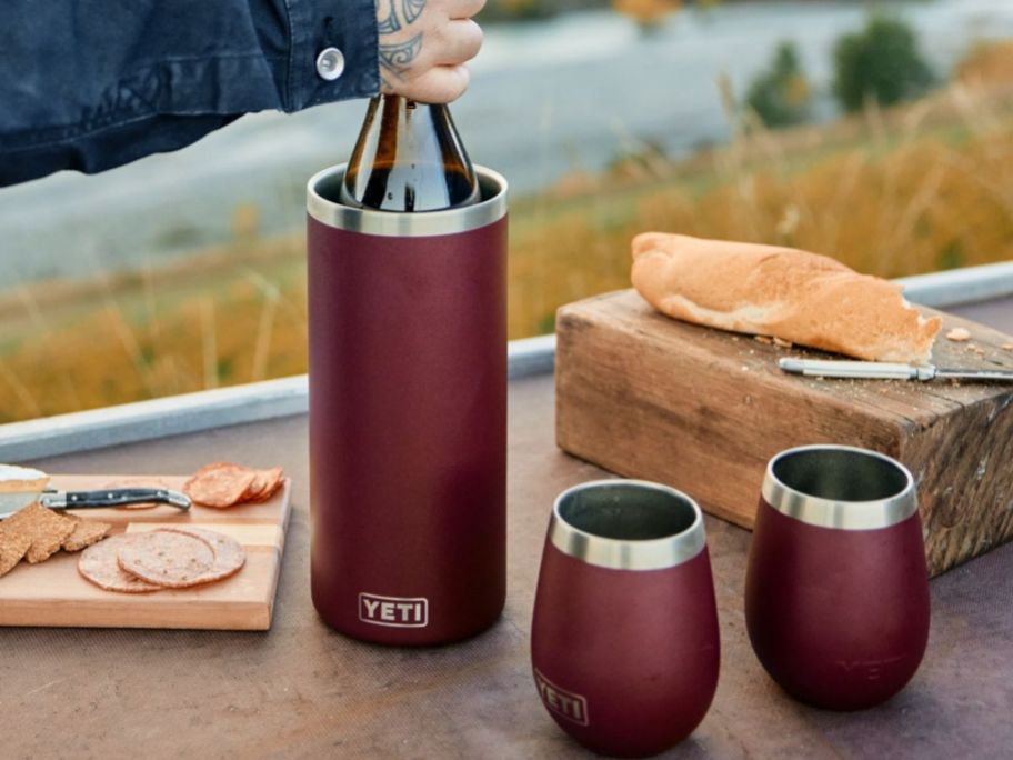 A YETI Wine Chiller and 2 Rambler Tumblers on a picnic table