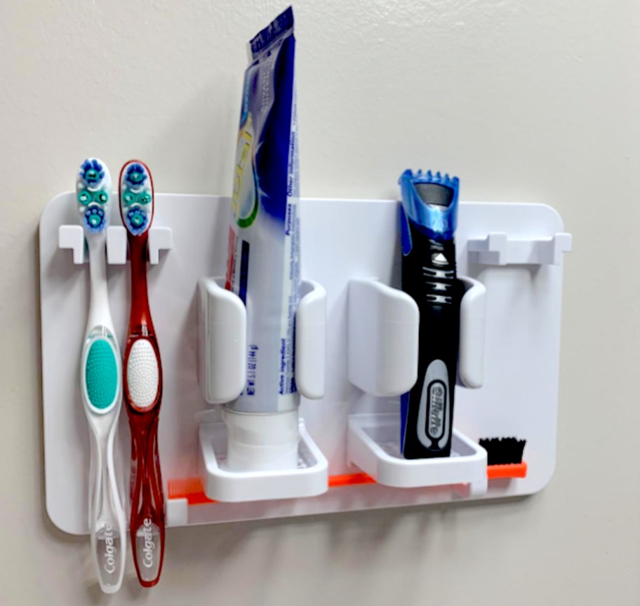 white toothbrush holder on wall with toothpaste and razor - small bathroom storage ideas