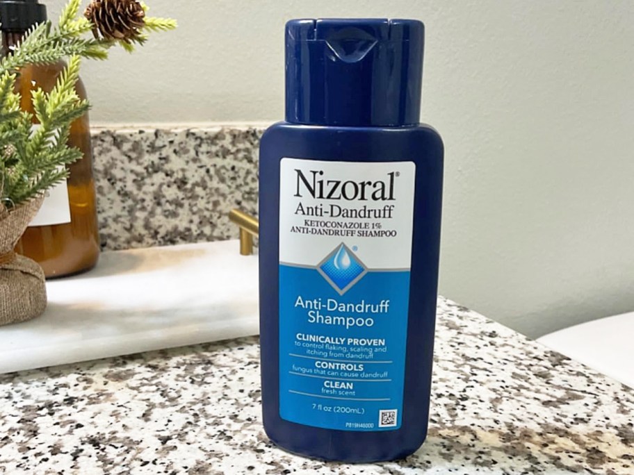 small blue bottle of Nizoral Anti-Dandruff Shampoo on bathroom counter