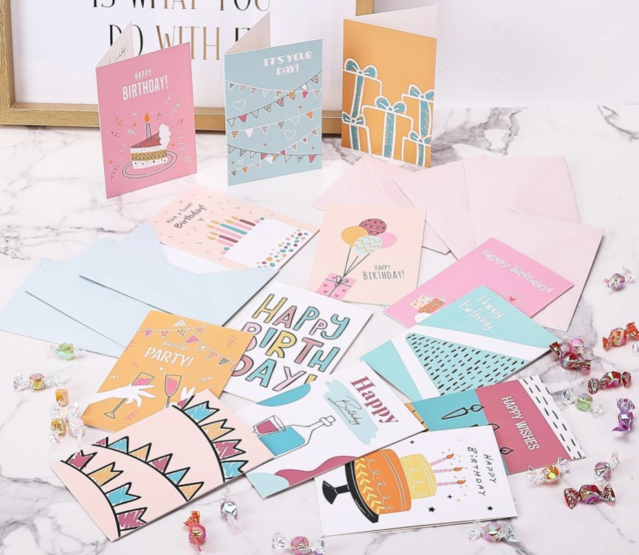 various birthday cards laid out on a table with candy