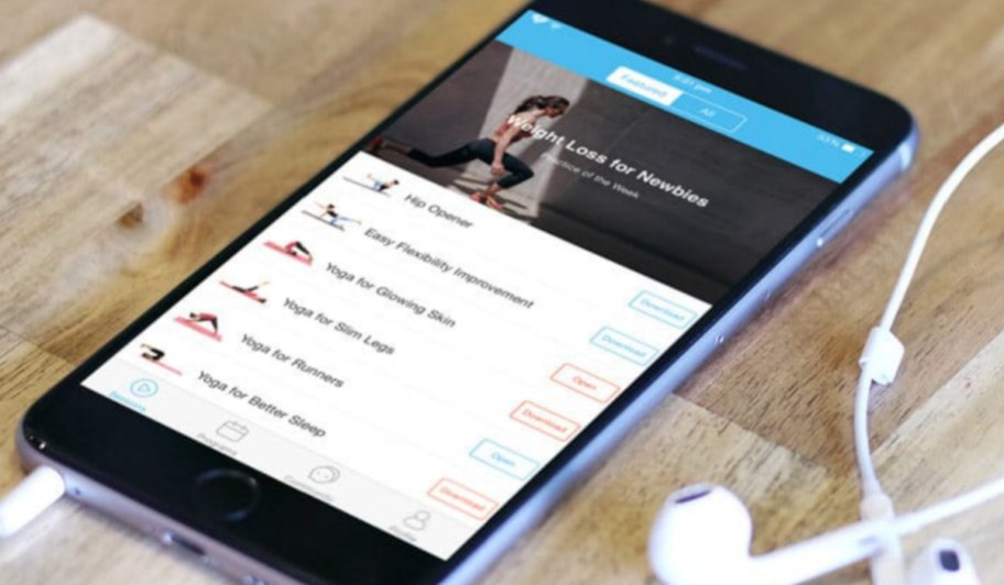 daily yoga app on phone screen with headphones free fitness apps