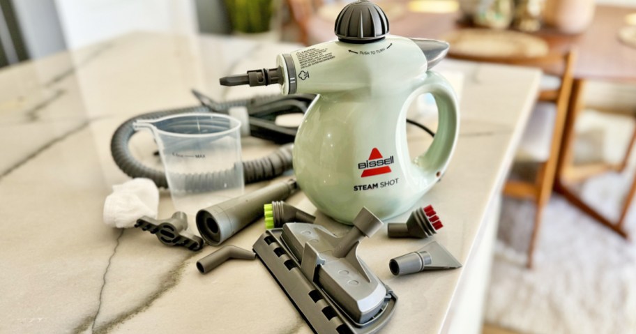 Bissell SteamShot cleaner with accessories and attachments on counter