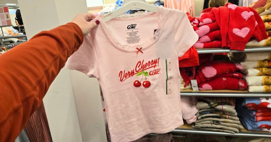 Women's Very Cherry Coke Cap Sleeve Graphic Baby T-Shirt in hand in store