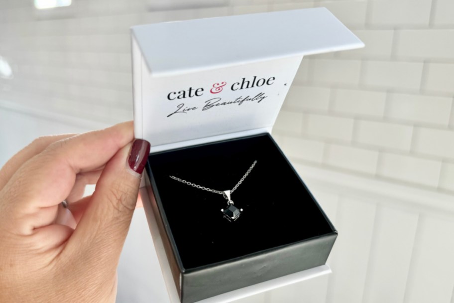 hand holding black crystal necklace in box