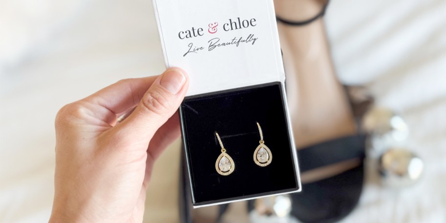 hand holding gold teardrop earrings 