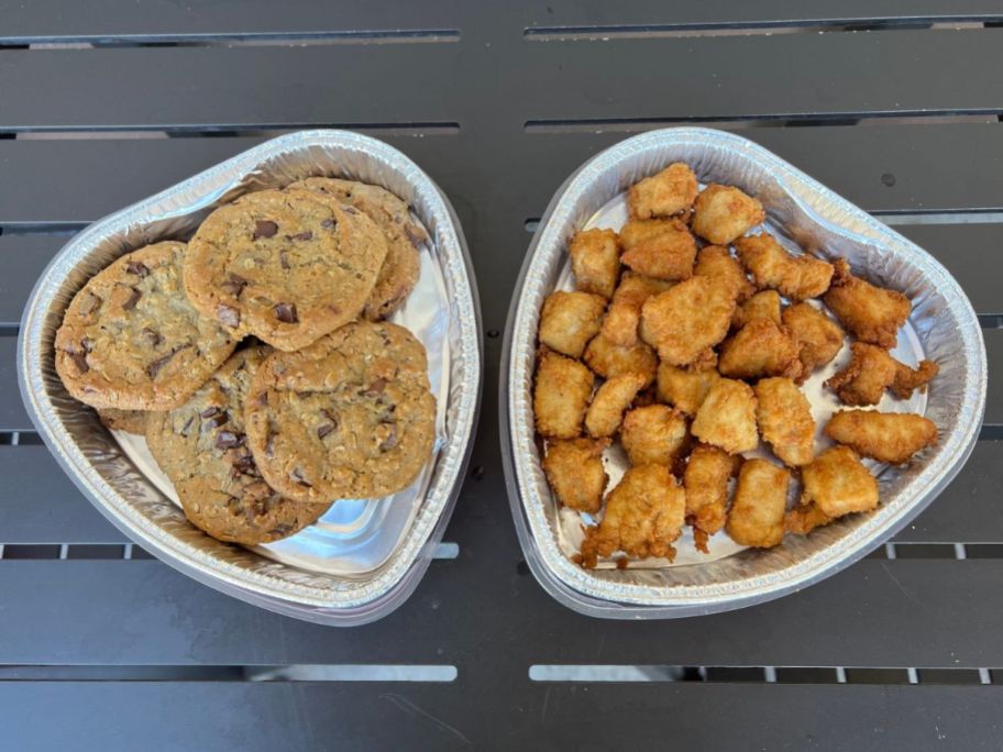 Two Chik-fil-a heart shaped trays filled with chocolate chip cookies and nuggets